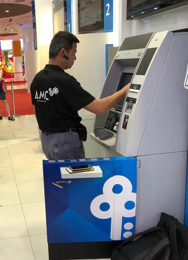 AMC First Line Engineer working at an ATM